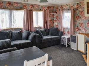 a living room with two couches and a table at Praise Machine Caravan Experience in Jaywick Sands