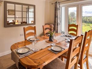 a wooden dining room table with chairs and a large window at Rosemeade in Hessett