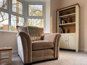 a living room with a chair and a book shelf at Rosemeade in Hessett