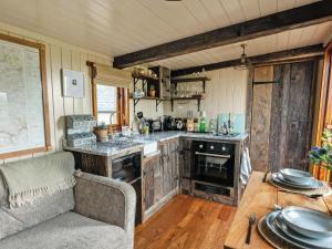 a kitchen with a table and a couch in a room at Bailey Huts in Litton