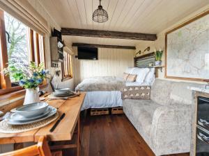 a living room with a couch and a bed at Bailey Huts in Litton