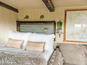 a bed with white pillows in a room at Bailey Huts in Litton +2 photos