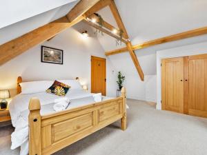 a bedroom with a wooden bed in a attic at Knoll View Ranch in Shepton Mallet +15 photos