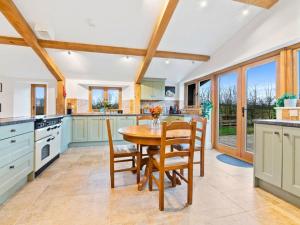 a kitchen with a wooden table and chairs at Knoll View Ranch in Shepton Mallet