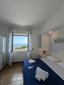 a bedroom with a large bed with two towels on it at Hotel La Plancia in Otranto