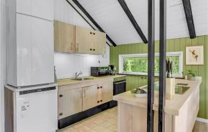 a kitchen with wooden cabinets and a white refrigerator at Holiday Home Østmarken Toftlund Denm in Toftlund