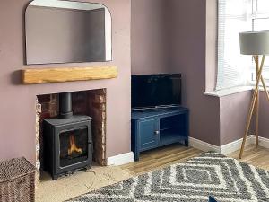 a living room with a fireplace and a tv at Longshore in Runswick