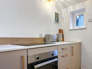 a kitchen with a stove top oven next to a counter at Longshore in Runswick
