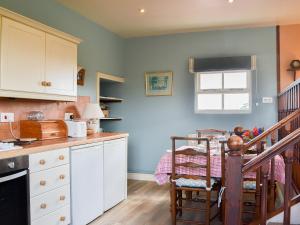 a kitchen with a counter and a table and a staircase at Bugatti House in Bosbury