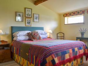 a bedroom with a bed with a colorful blanket at Bugatti House in Bosbury +7 photos