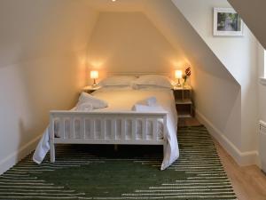 a bedroom with a bed with white sheets and pillows at Hope Cottage - Uk40055 in Aberfeldy