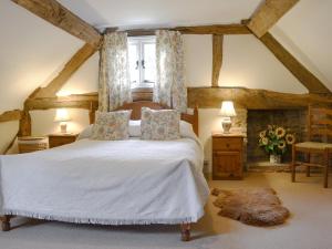 a bedroom with a large white bed with a window at Hollywall Croft in Stoke Prior +8 photos