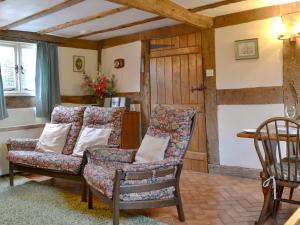 a living room with a couch and a chair at Hollywall Croft in Stoke Prior