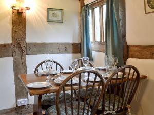 a wooden table with chairs and glasses on it at Hollywall Croft in Stoke Prior