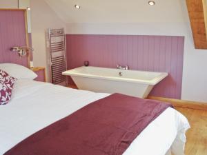 a bathroom with a bed and a bath tub at Bwthyn Celyn-Oa6 in Ystrad Meurig