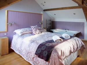a bedroom with a large bed and a bath tub at Bwthyn Celyn-Oa6 in Ystrad Meurig