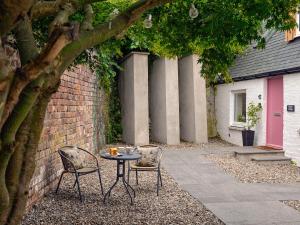 a table and two chairs next to a brick wall at Harris Cottage - Uk40056 in Aberfeldy +2 photos