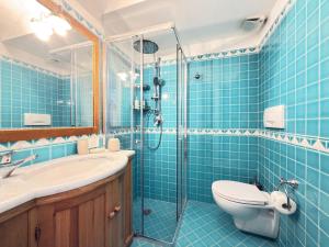 a blue tiled bathroom with a toilet and a shower at Domus Floris in Positano