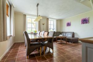 a dining room with a table and a couch at t Huysje van Klippel in Tholen