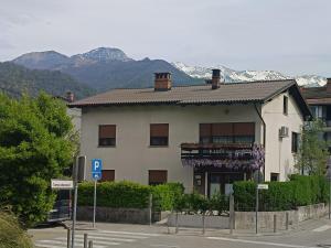 a large white building with mountains in the background at Gravitacija East in Tolmin