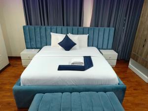 a bed with a blue headboard and a blue couch at Captain Residency Hotel in Lagos