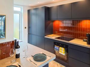 a kitchen with black cabinets and a table with wine glasses at The Lobster Pot in Shotley Gate