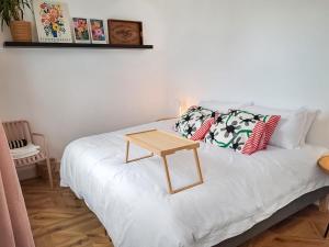 a white bed with a wooden table on it at The Lobster Pot in Shotley Gate +5 photos