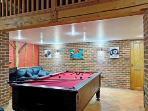 a pool table in a room with a brick wall at Clamp Farm Barn in Stowmarket