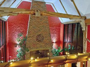a room with a brick wall and a clock on the wall at Clamp Farm Barn in Stowmarket