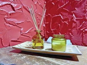 a plate with two jars of yellow liquid and sticks at Clamp Farm Barn in Stowmarket +35 photos
