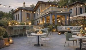 eine Terrasse mit Tischen und Stühlen vor einem Gebäude in der Unterkunft Hotel Colonne in Varese