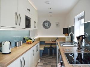 a kitchen with white cabinets and a counter top at Waterloo Farm House in Bankfoot