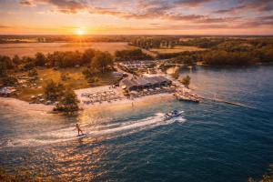 an island in the water with a boat on it at Hotel ALMA in Wassenberg