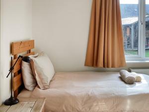 a small bedroom with a bed with a window at Keepers Cottage - Uk51549 in Kirktown of Auchterless