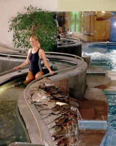 a woman standing in front of a water fountain at Appartamenti Vacanze Casa -Residence Albare - check in Vacanze Casa - Marilleva 900 in Marilleva