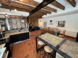 an open kitchen and dining room with wooden ceilings at L'échappée in Neulliac