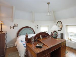 a bedroom with a bed and a wooden desk at Ryegate Cottage in Helmsley