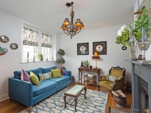 a living room with a blue couch and a fireplace at Ryegate Cottage in Helmsley