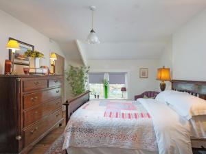 a bedroom with a large bed and a dresser at Ryegate Cottage in Helmsley +7 photos