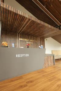 a reception area in a room with a wooden floor at Drizzle Drop Inn in Ooty