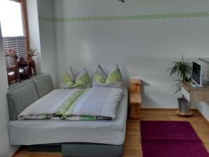 ein Schlafzimmer mit einem Bett mit grünen Kissen darauf in der Unterkunft SchormisBleibe in Schwendau