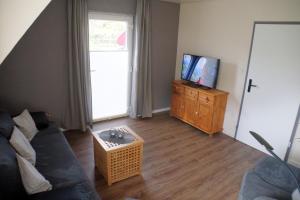 a living room with a couch and a tv at Ferienwohnungen Reinhilde - Litzig in Traben-Trarbach