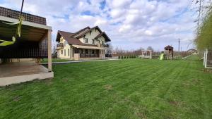 a yard with a house and a soccer field at Dor de Casa in Doljeşti