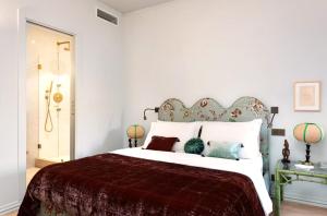 a bedroom with a large bed with white sheets and pillows at Elegant Seafront Apartment in Ostia in Lido di Ostia