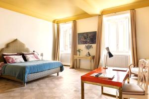 a bedroom with a bed and a table and a desk at Elegant Seafront Apartment in Ostia in Lido di Ostia