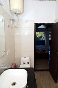 a bathroom with a toilet and a sink and a bed at Shanti Residency Ramgarh in Rāmgarh