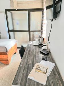 a room with a table with a bed and a book at SapzRes at Klerksdorp in Klerksdorp