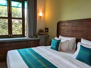 a bedroom with a large bed with green and white pillows at Spacious 2 Bedroom Apartment with Lake View in Tangalle