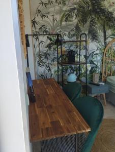 a wooden table and a green chair in a room at Chambre 2 pers SPA Piscine in Grospierres