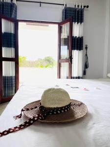 a straw hat sitting on a bed with a window at FA Resort in Panama